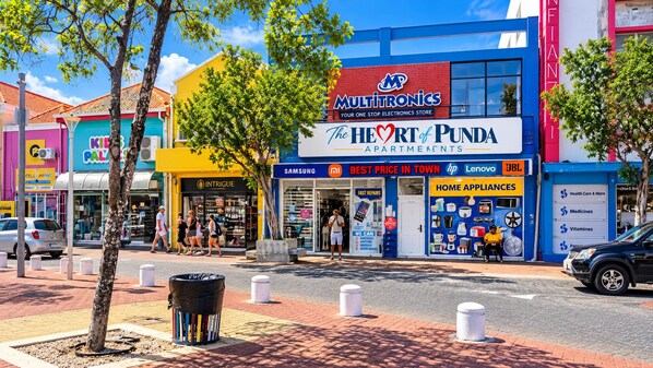 A commercial street with a Multitronics store, a Samsung store, and The Heart of Punda apartments. - The Heart of Punda Studio 2 King Size beds (Willemstad)