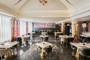 A spacious restaurant with multiple tables and chairs, a marble floor, and a large screen displaying a cityscape. - Chongqing Hongyadong Mehood Elegant (Chongqing)