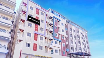 A multi-story residential building with balconies, a ground-level shop, and a sign indicating 'OYO TOWNHOUSE.'