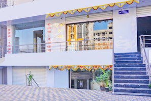 A building with a staircase, a security camera, and a sign indicating surveillance.