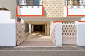Entrada de um edifício com uma entrada de automóveis protegida e um corredor coberto.