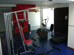 A gym with exercise equipment, a treadmill, and a bench. - Hotel Brisolei (San Bernardo del Tuyú)