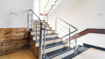 Una escalera con barandilla metálica y escalones de madera.