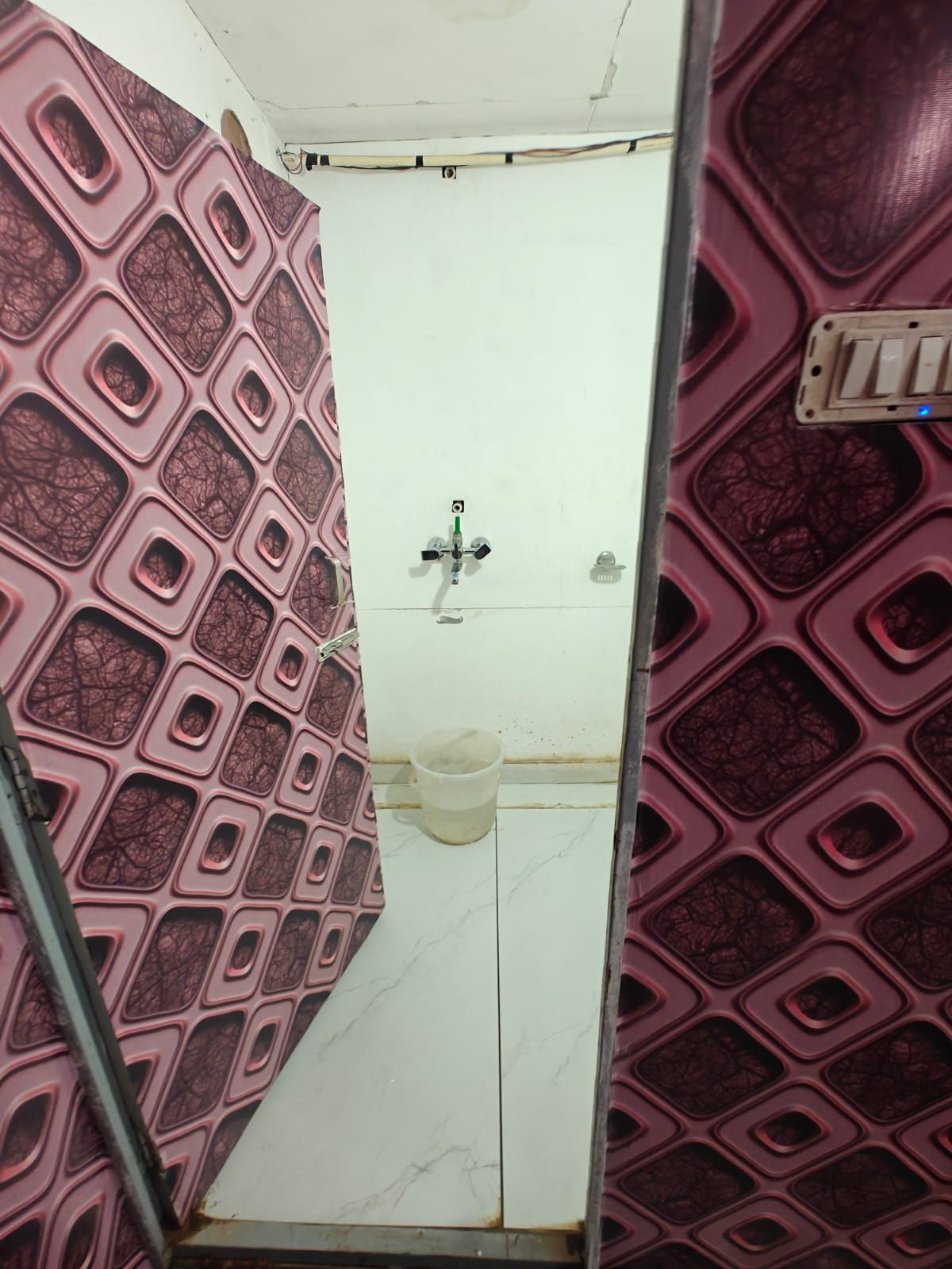 Un bagno con pavimento piastrellato di bianco, un lavandino con rubinetto e un water.