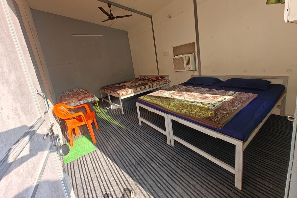 Un dormitorio con una cama, un escritorio, una silla y un ventilador de techo.