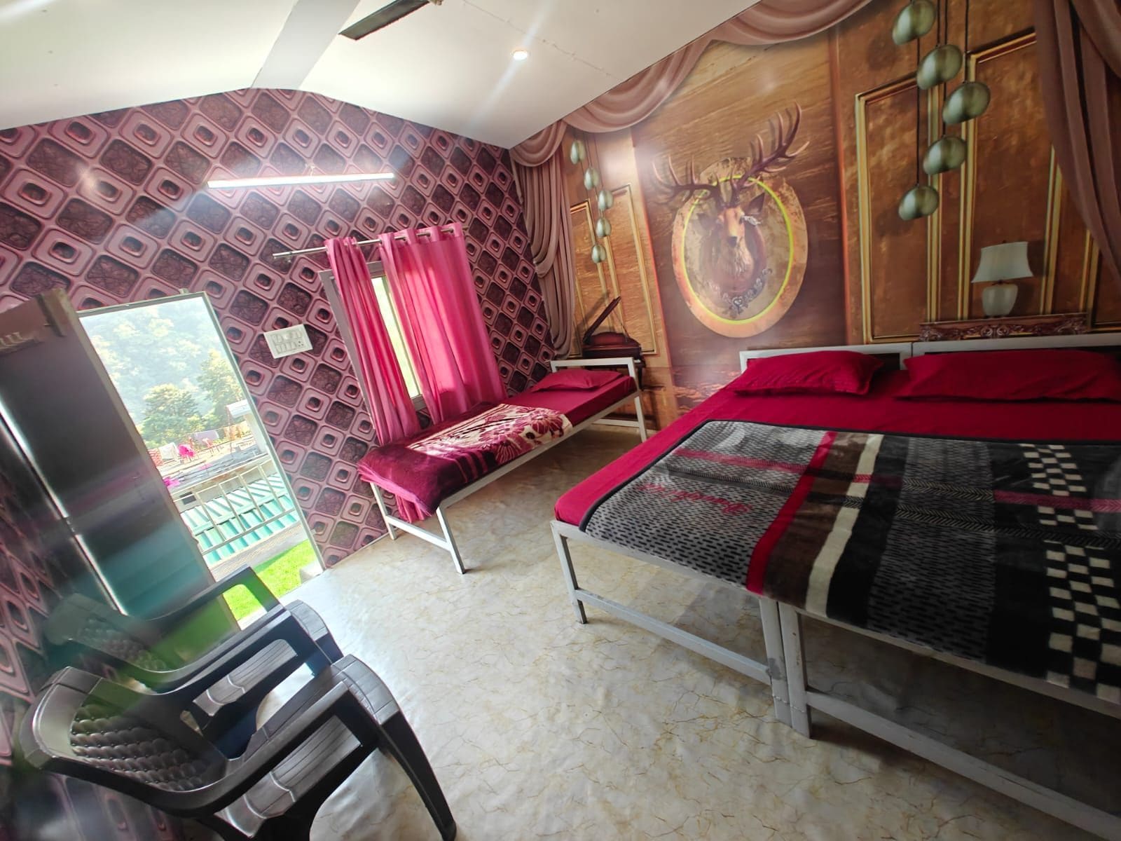 A bedroom with a bed, a desk, and a chair. There is a window with curtains, a wall with a patterned design, and a wall with a circular design.