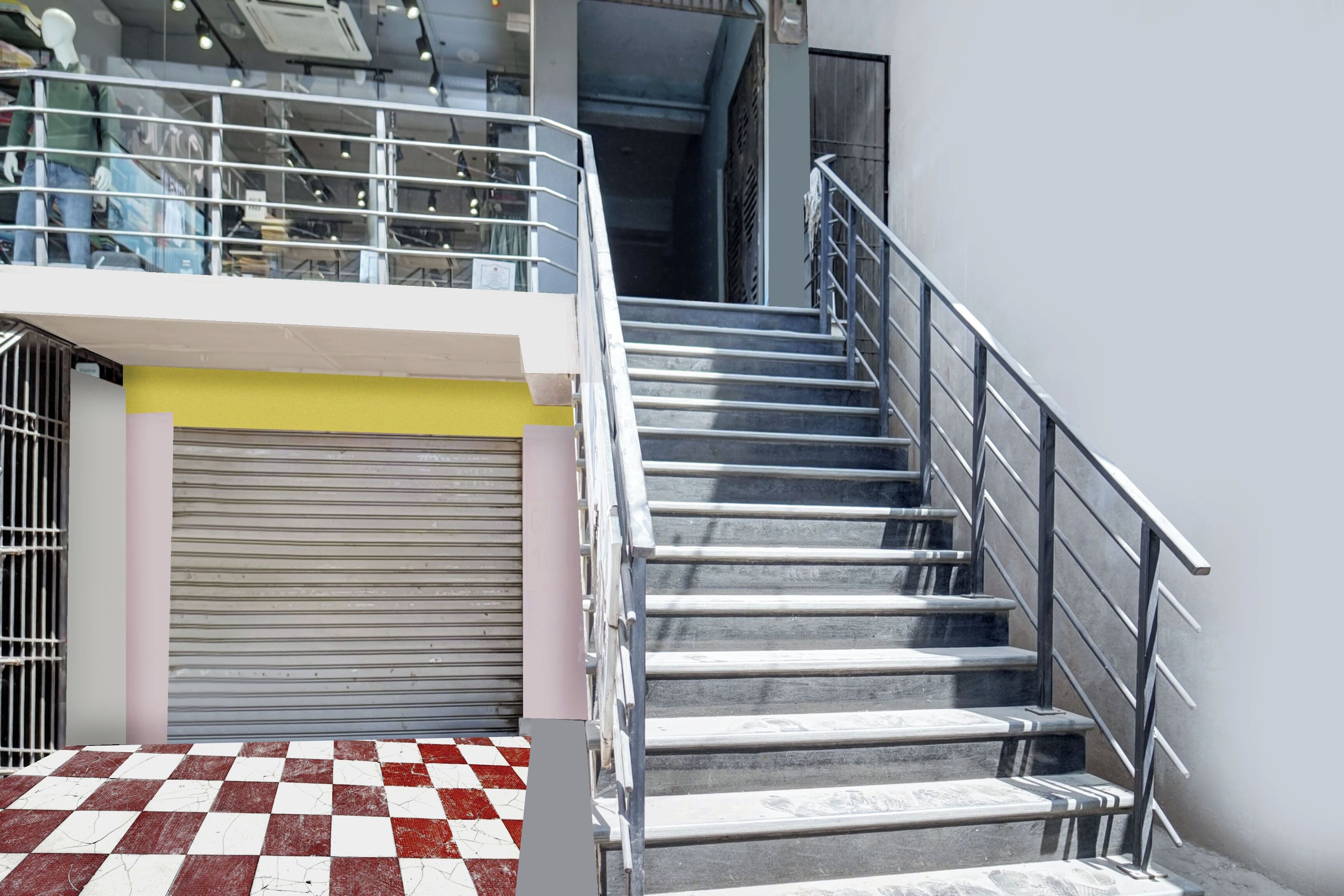 A staircase with metal railings leading to a second-floor area with a glass railing.
