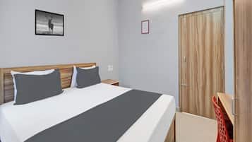 Un dormitorio con cama, mesita de noche, armario y un cuadro en la pared.