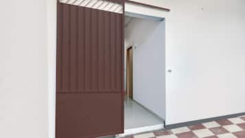 Una habitación con piso a cuadros, una puerta corredera y un pasillo visible.