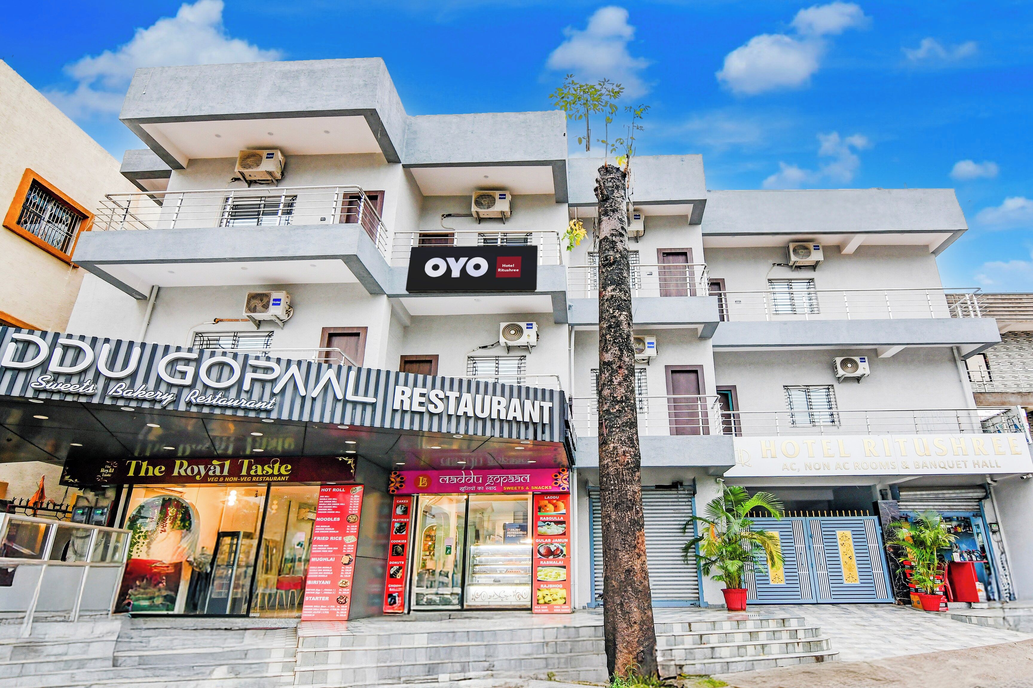 A multi-story building with a restaurant named 'GOPNN' on the ground floor, an 'OYO Hotel' on the second floor, and a 'HOTEL RITUSHREE' on the third floor.
