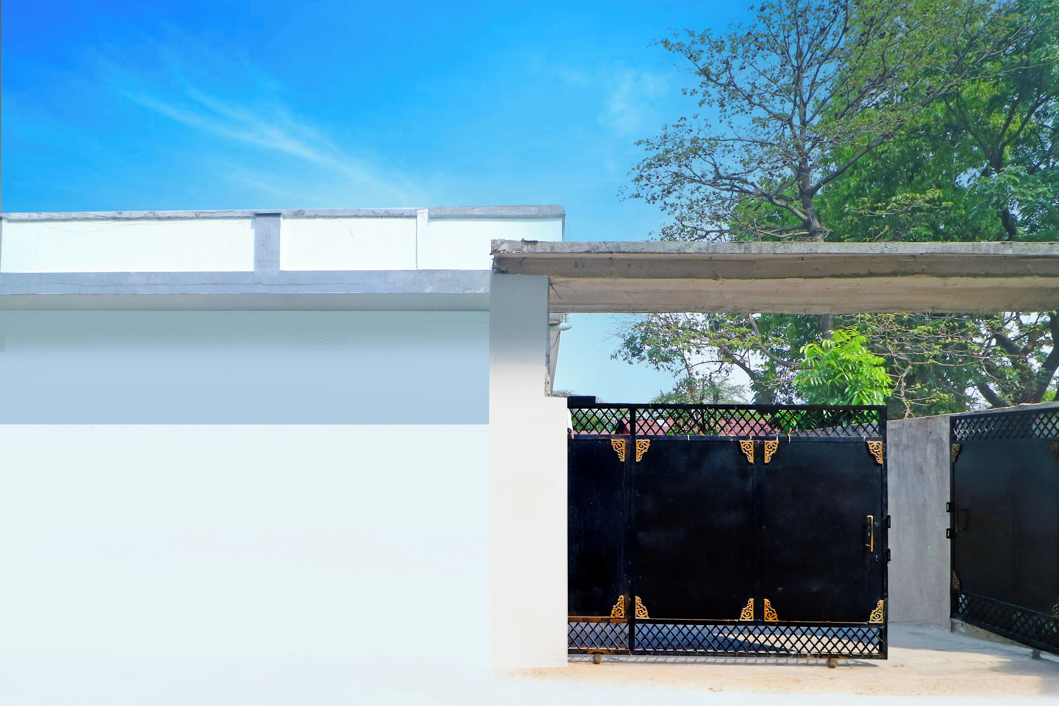 A gated entrance with a black gate and decorative metalwork.