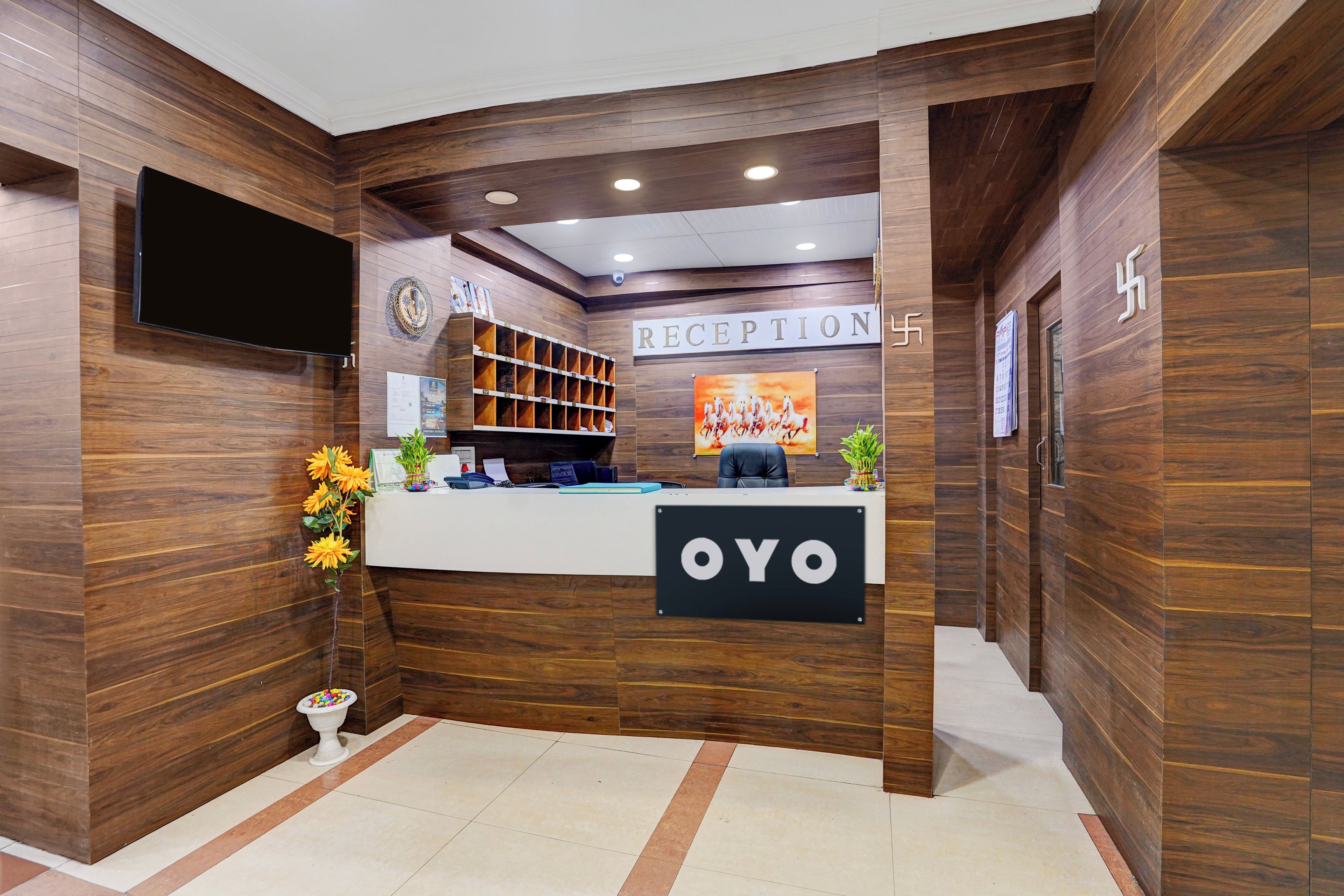 A reception area with a wooden interior, a reception desk, a television, and a sign that reads 'RECEPTION'.