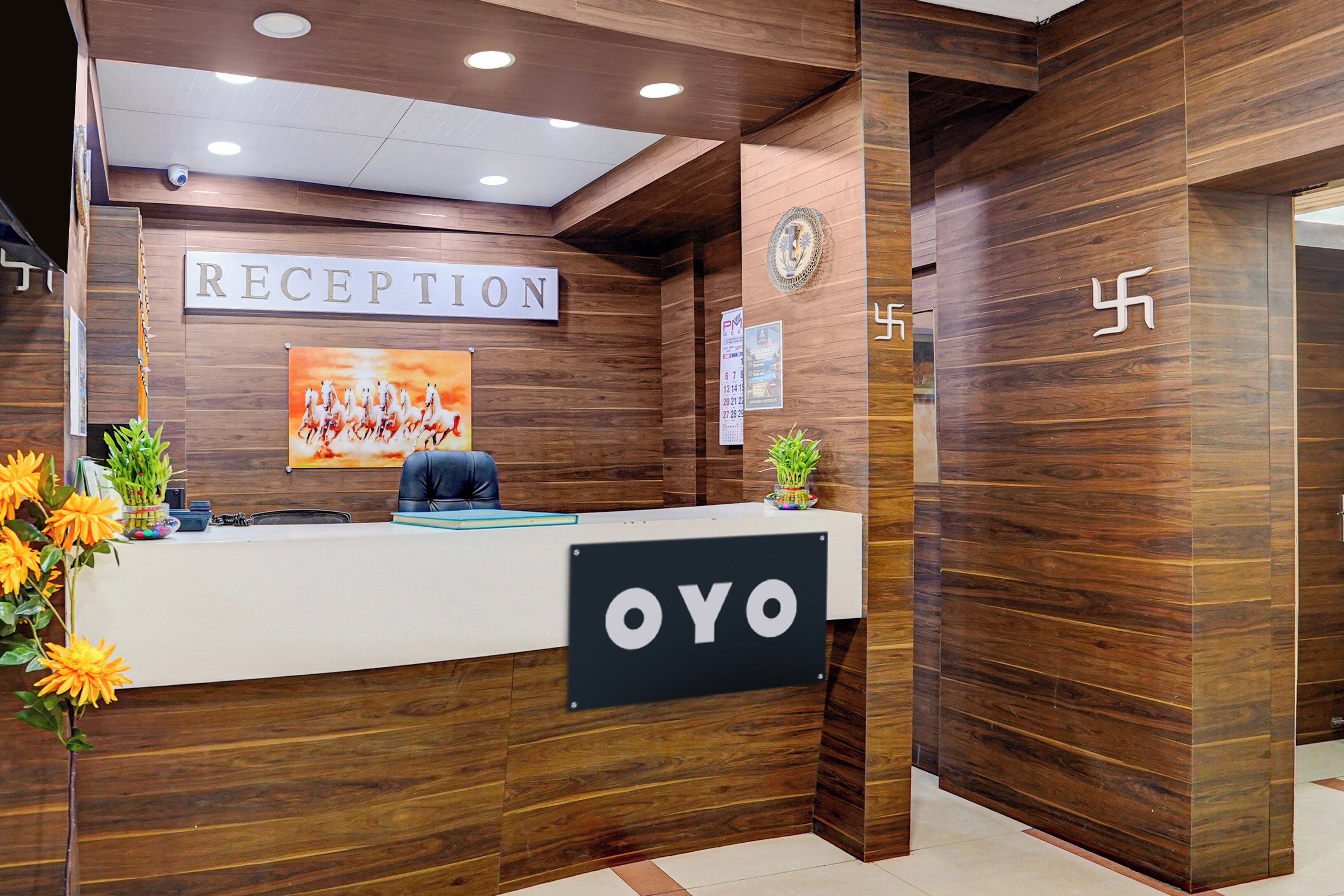 A reception desk with a 'RECEPTION' sign, a 'YOYO' sign, a calendar, and a wall-mounted emblem.