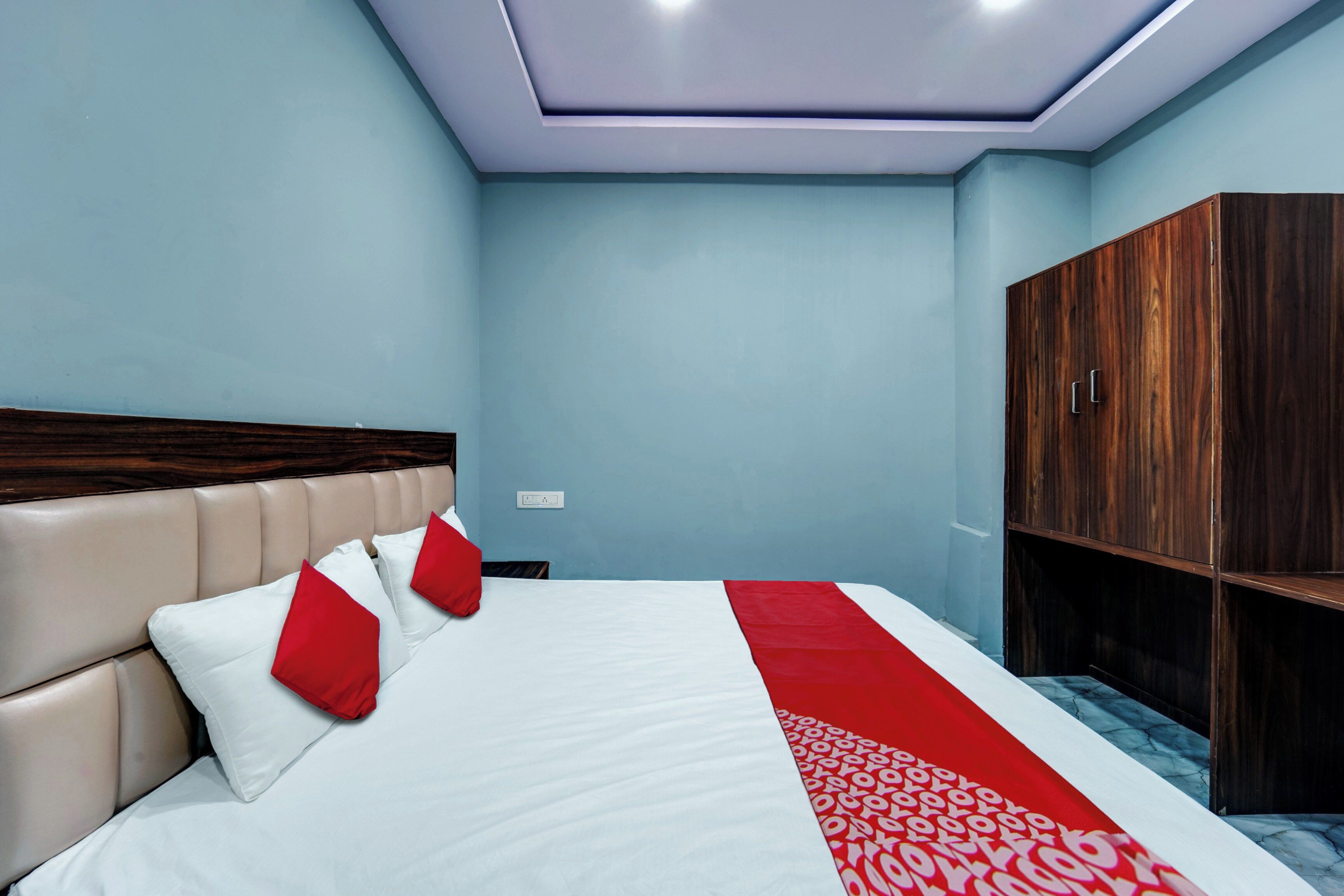 A hotel room with a bed, a wardrobe, and a ceiling light.