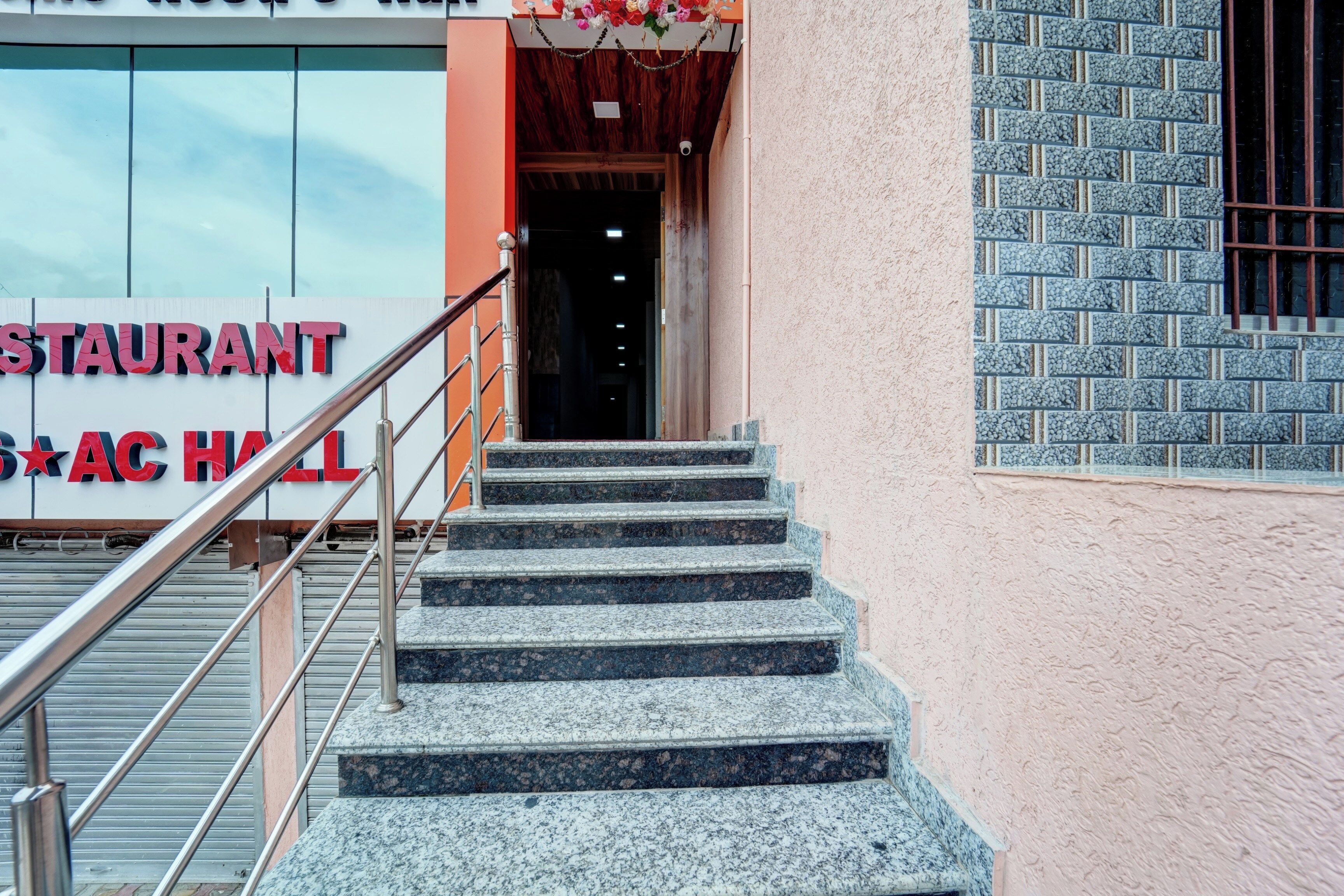 A staircase leading to a building entrance with a sign reading 'STAURANT AC HALL'.