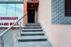 Una escalera conduce a la entrada de un edificio, con un letrero que dice 'STAURANT AC HALL'.