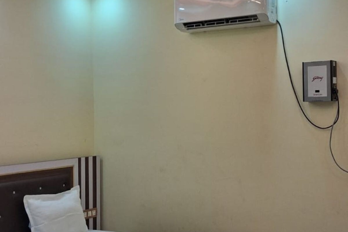 Quarto com cama, ar condicionado e ventilador de teto.