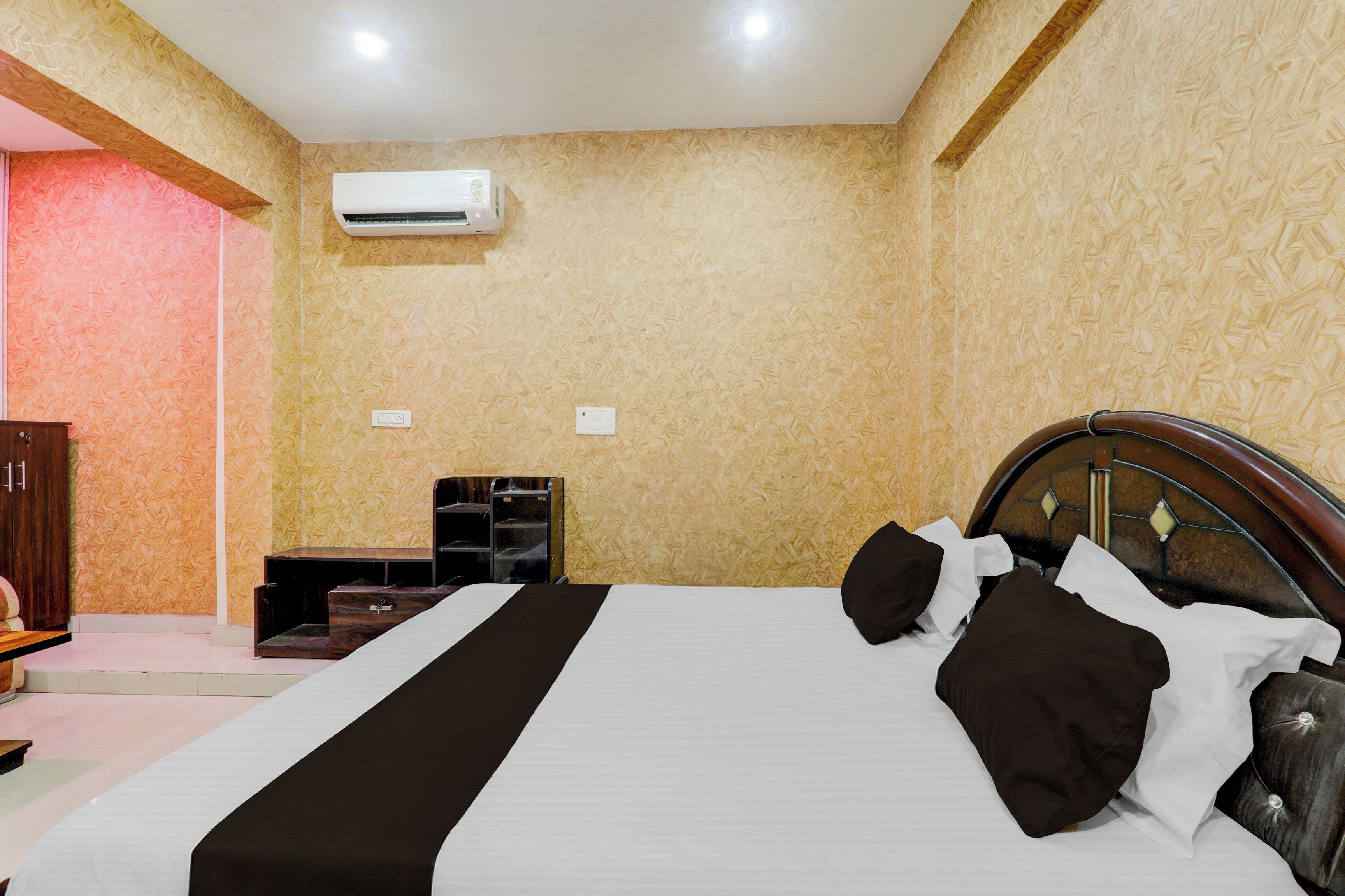 Une chambre à coucher comprenant un lit, une armoire, une table de chevet et un appareil de climatisation.