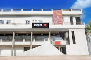 A hotel building with a sign for 'OYO Hotel Yash Raj Palace' and a promotional banner for a 50% off parking offer.