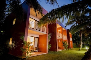 A modern two-story building with a balcony on the upper floor, surrounded by greenery. - Mantis Soanambo Hotel and Spa Sainte Marie (Nosy Boraha)