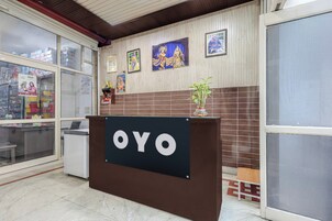 Una recepción con el nombre 'OYO' y una planta en maceta encima.