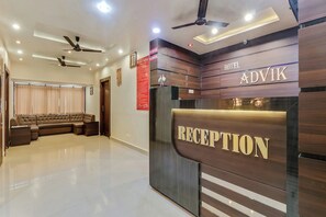 A hotel reception area with a reception desk, a seating area with sofas, and a ceiling fan. - Hotel O Royal (Rajnandgaon)