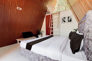 Quarto com cama, escada, escrivaninha e planta em vaso.