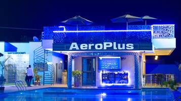 Un hôtel appelé AeroPlus, doté d’une piscine, d’un bar et d’une signalétique indiquant l’emplacement des toilettes.