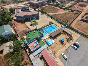Vista aérea de una zona residencial con piscina, patio cercado y varios edificios.
