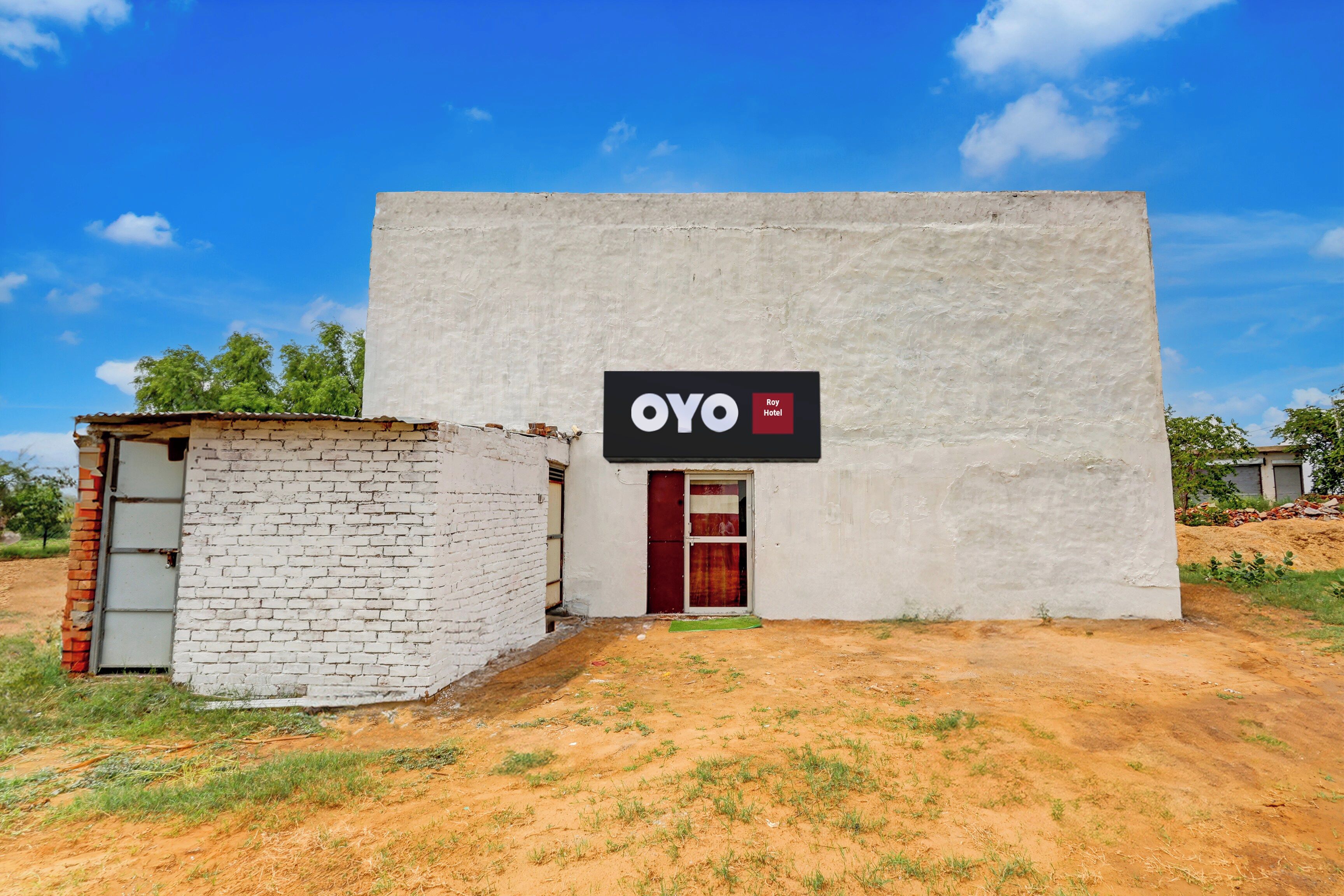 Um pequeno edifício térreo com a placa do Hotel OYO.