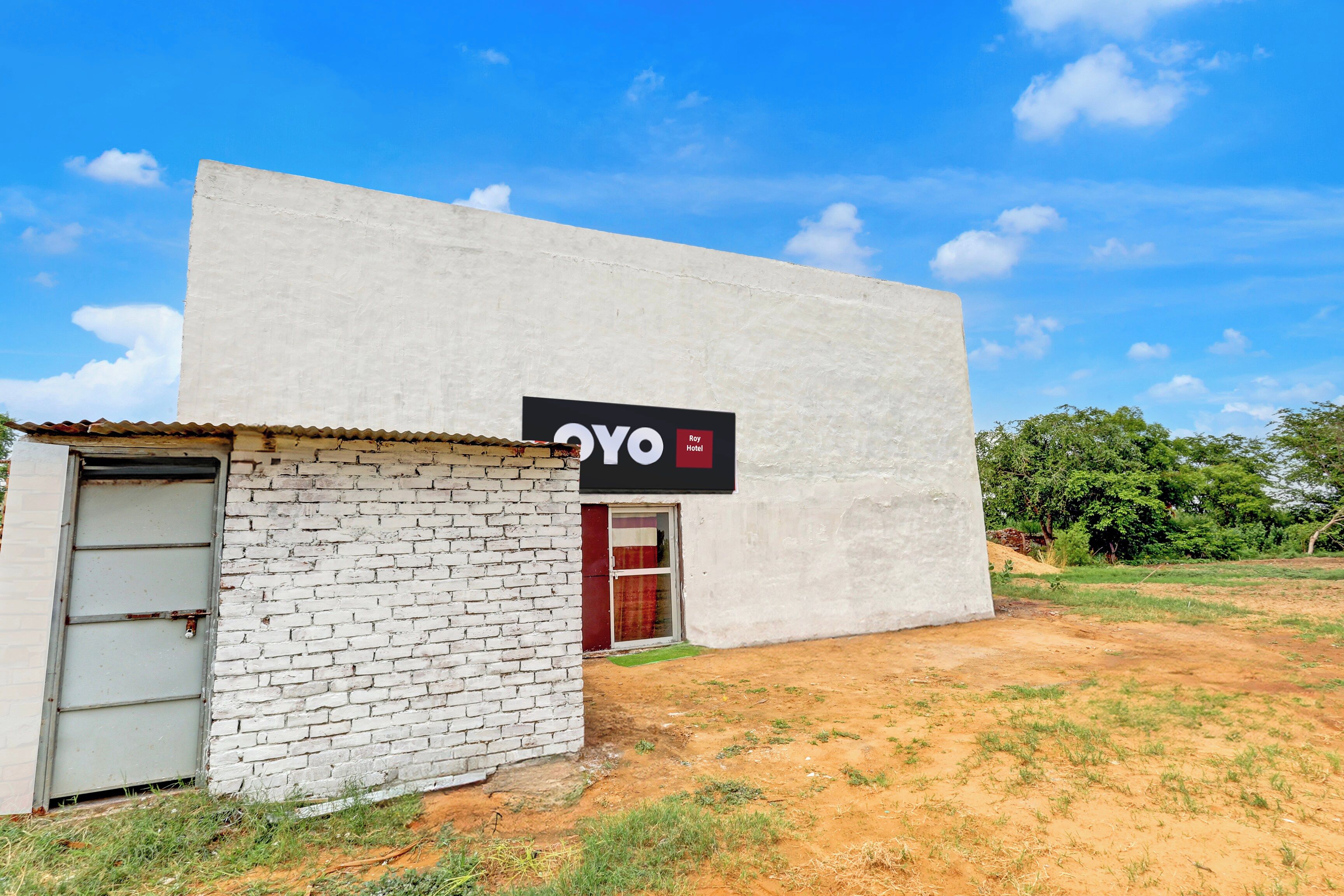 Um edifício com uma placa que diz 'OYO Roy Hotel'.