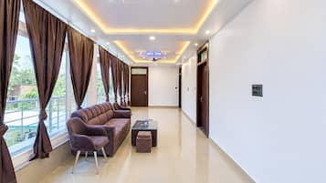 A modern living room with a sofa set, a coffee table, and a ceiling fan.