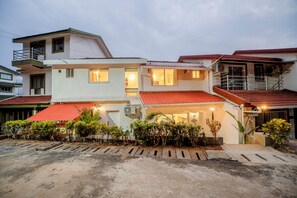 A two-story residential building with a red-tiled roof, multiple windows, and an air conditioning unit. - Staymaster Casa Rysa-3BR-Pool & Sea View (Nerul)