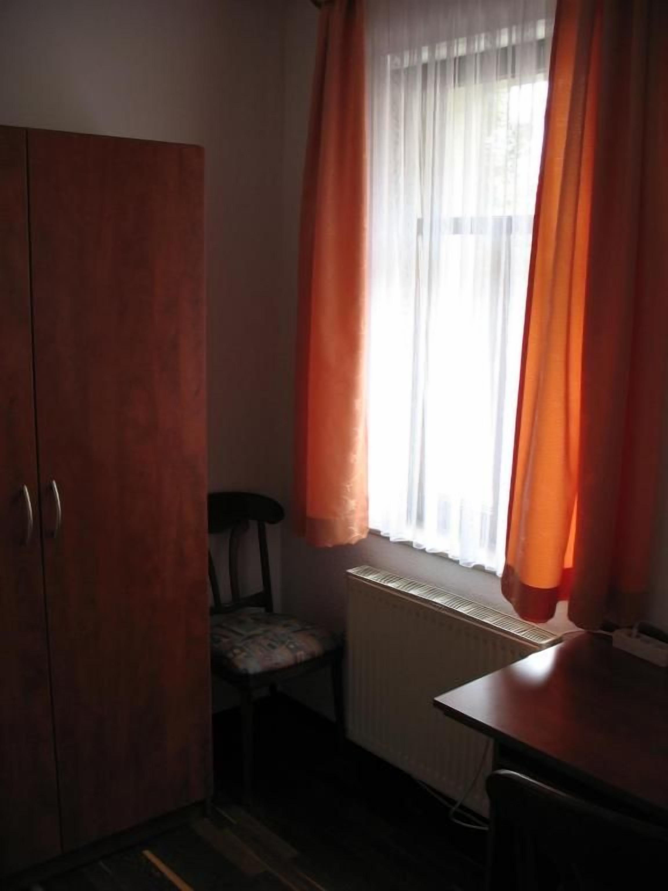 Une pièce avec un radiateur, une chaise et un bureau.