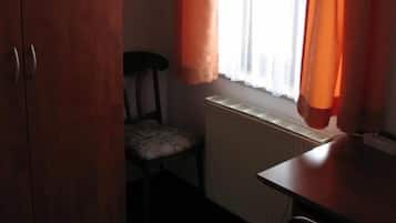 Ein Zimmer mit Heizkörper, Stuhl und Schreibtisch.