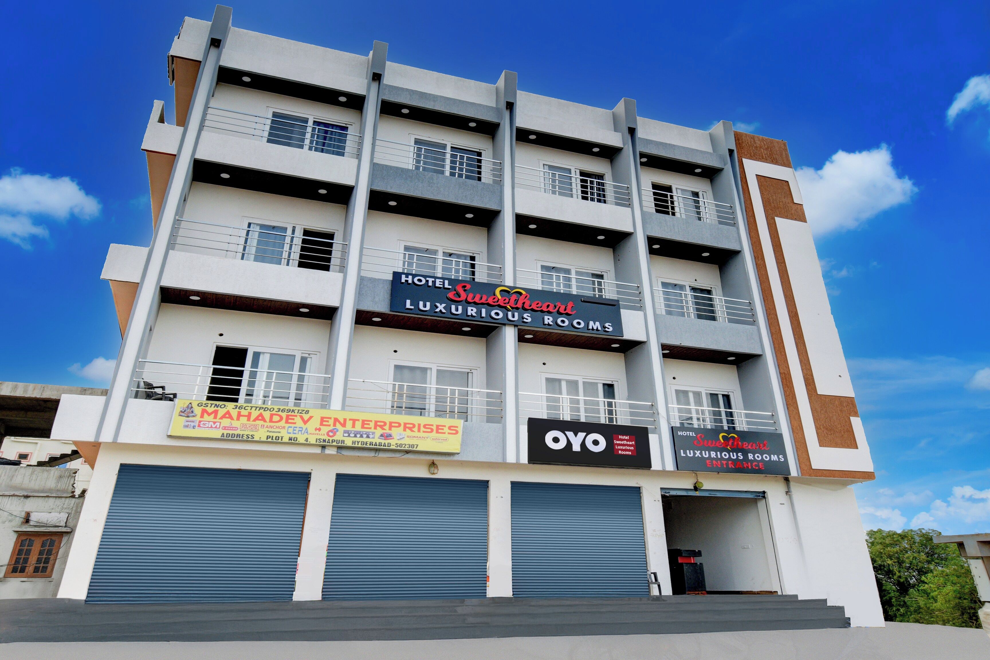 A multi-story hotel with signage for 'Sweetheart Luxury Rooms' and 'OYO Hotel Sweetheart Luxury Rooms Entrance'.