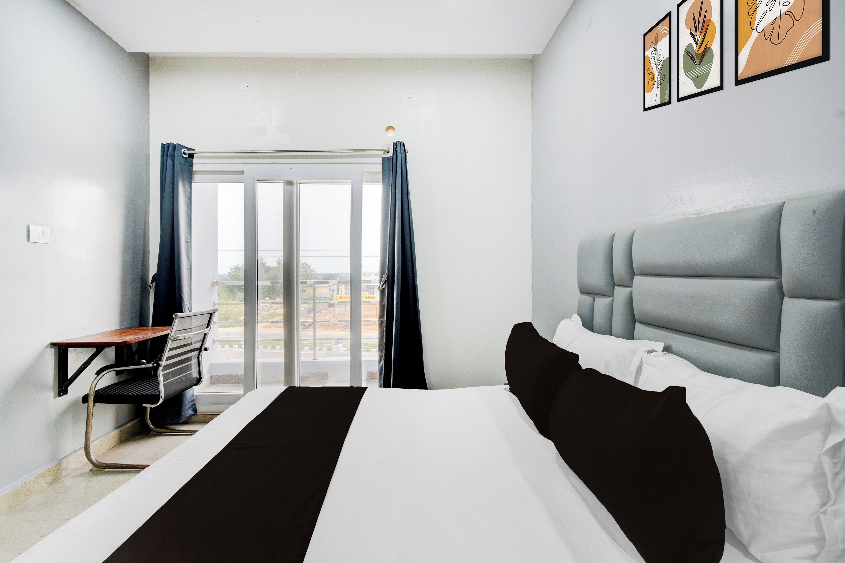 Ein Hotelzimmer mit einem Bett, einem Schreibtisch und Blick ins Freie.