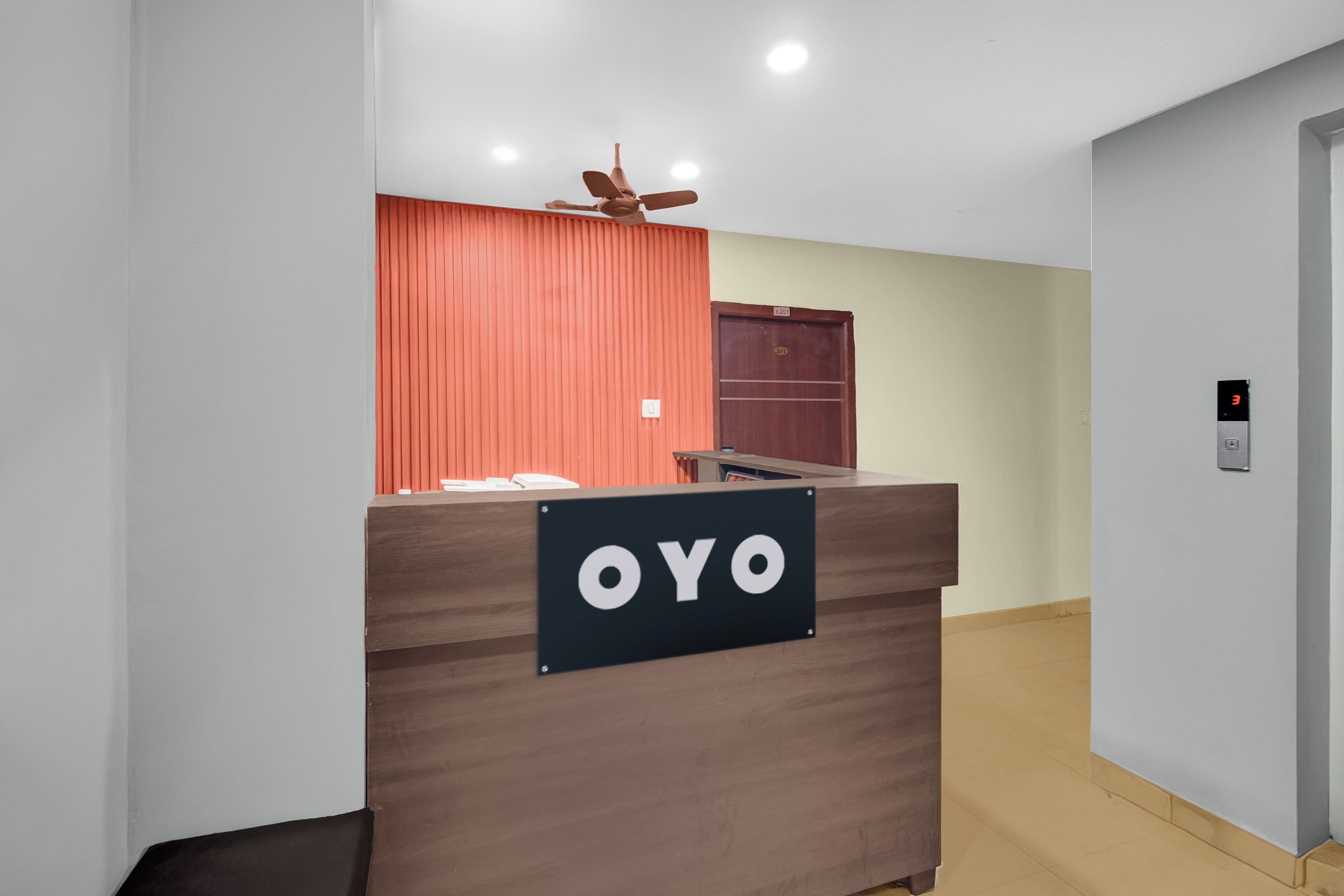 Una mesa de recepción con un cartel que dice 'OYO' en el vestíbulo de un hotel.