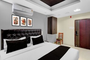 Una habitación de hotel con cama, armario, silla y puerta.
