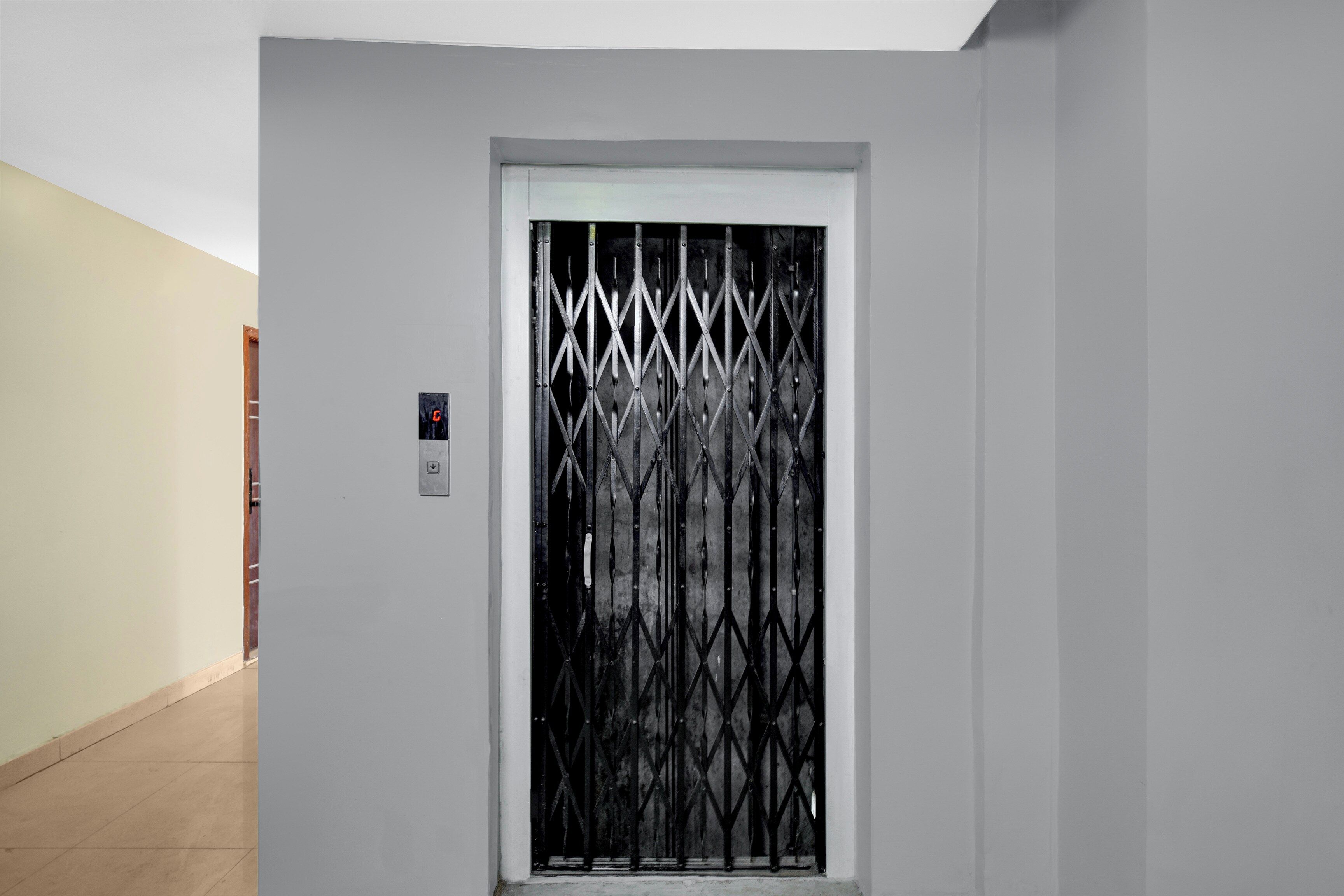 A hallway with a door featuring a metal security gate.