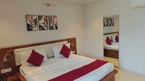 A hotel room with a bed, a mirror, and artwork on the wall. - Hotel O Bulbul Hotel (Rohtak)