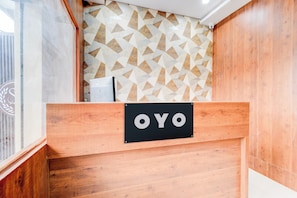 Ein Empfangsschalter mit Wandgestaltung in geometrischem Muster und einem Schild mit der Aufschrift 'OYO'.