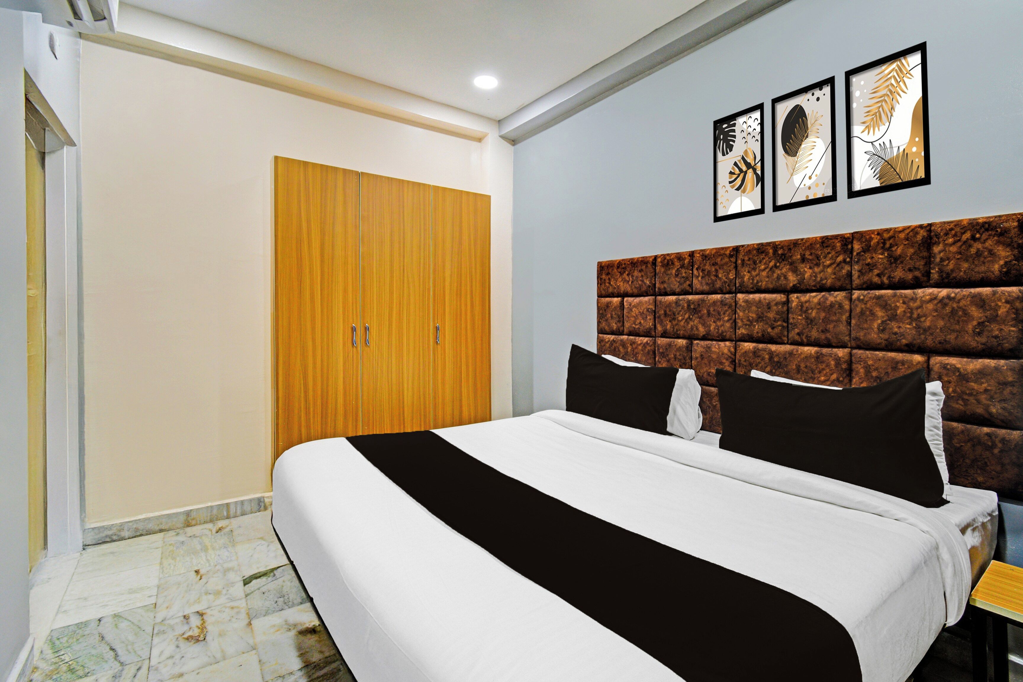 A bedroom with a bed, a wardrobe, and a headboard.