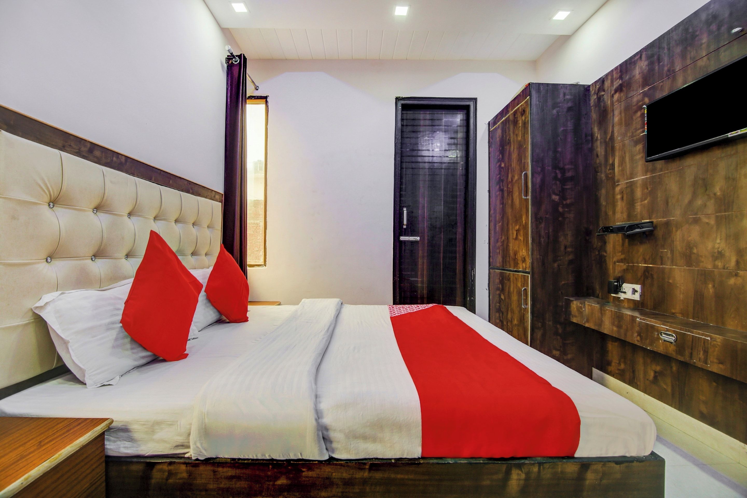 A bedroom with a bed, a wardrobe, and a television.