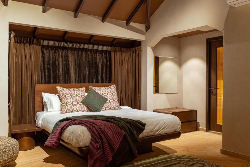 Ein Schlafzimmer mit einem hölzernen Bett, einem Nachttisch und einem großen Fenster mit Vorhängen.