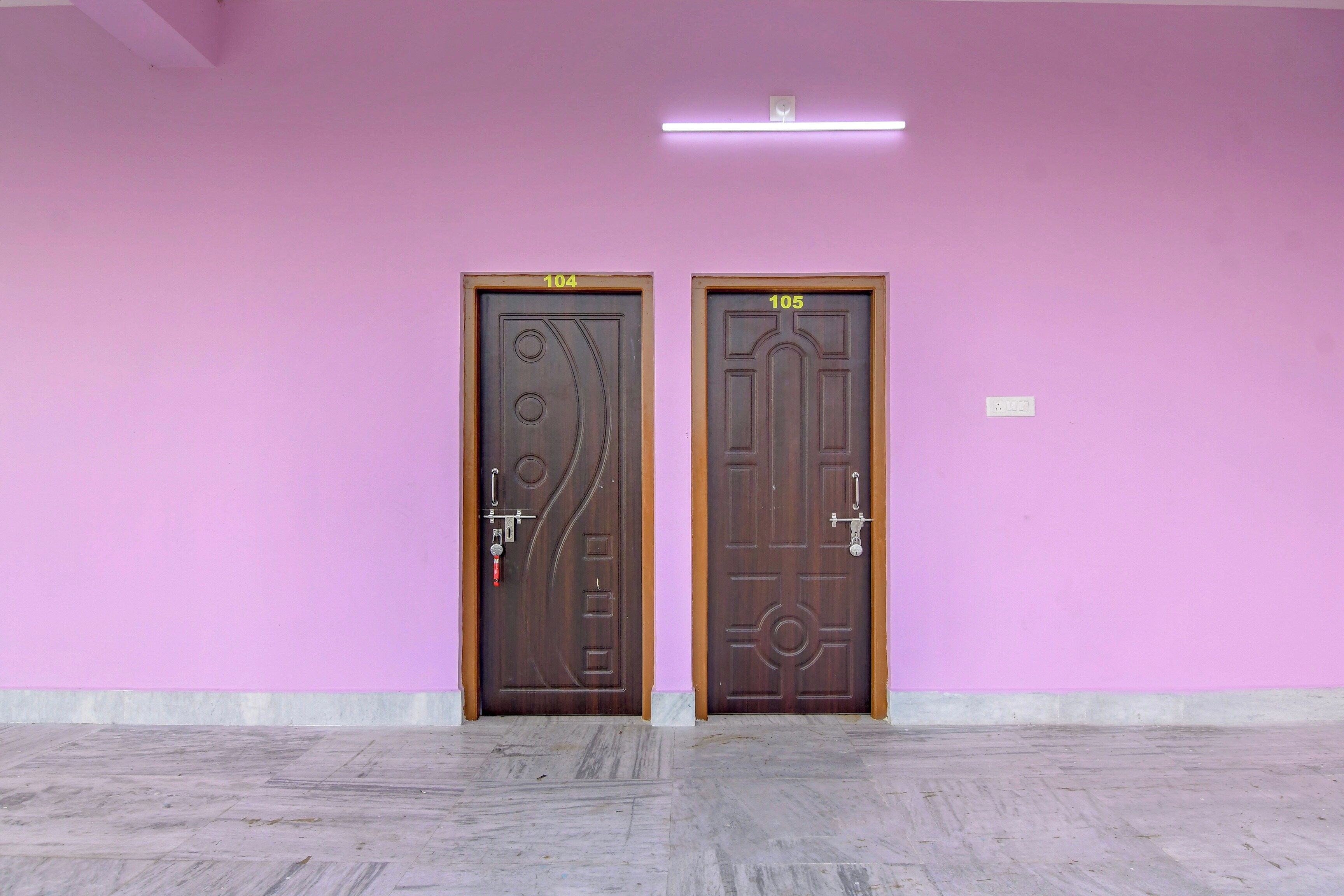 Two doors with numbers 104 and 105, a light fixture above, and a tiled floor.