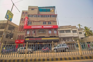 A multi-story building with a prominent red sign for 'Kshounish Residency Hotel' and a 'Royal Enfield' motorcycle shop below. - Hotel O Kshounish Residency (Malda)