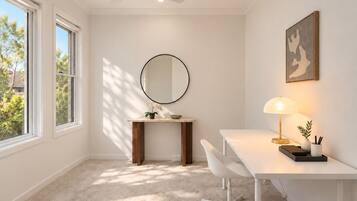 A modern room with a desk, chair, and a round mirror.