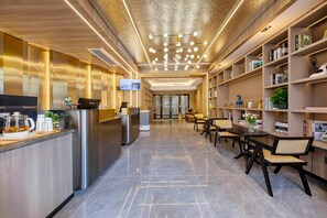 Un espace d’accueil moderne comprenant un comptoir de réception, un coin salon et une bibliothèque.