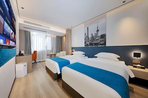 Une chambre d’hôtel avec deux lits, un bureau, une chaise, une petite table et une décoration murale représentant un paysage urbain.
